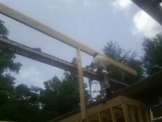 Carpenter setting a ridge beam over a new addition frame — Ice Dam Removal by Roofing Brothers in Oakham