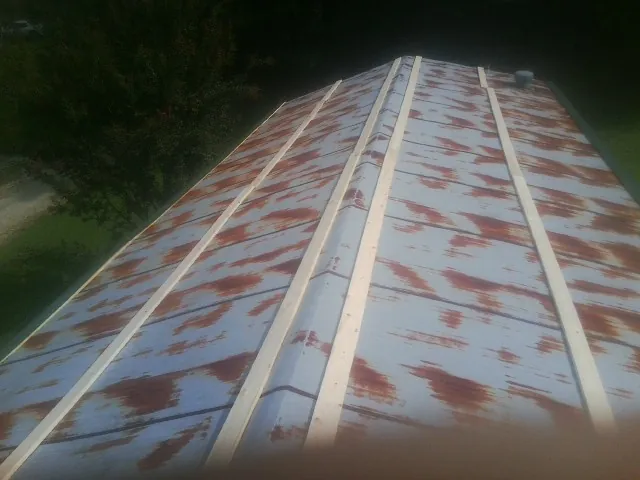 Rusted metal roof panels with new wood purlins before replacement — Storm Damage Roof Repair in Oakham by Roofing Brothers