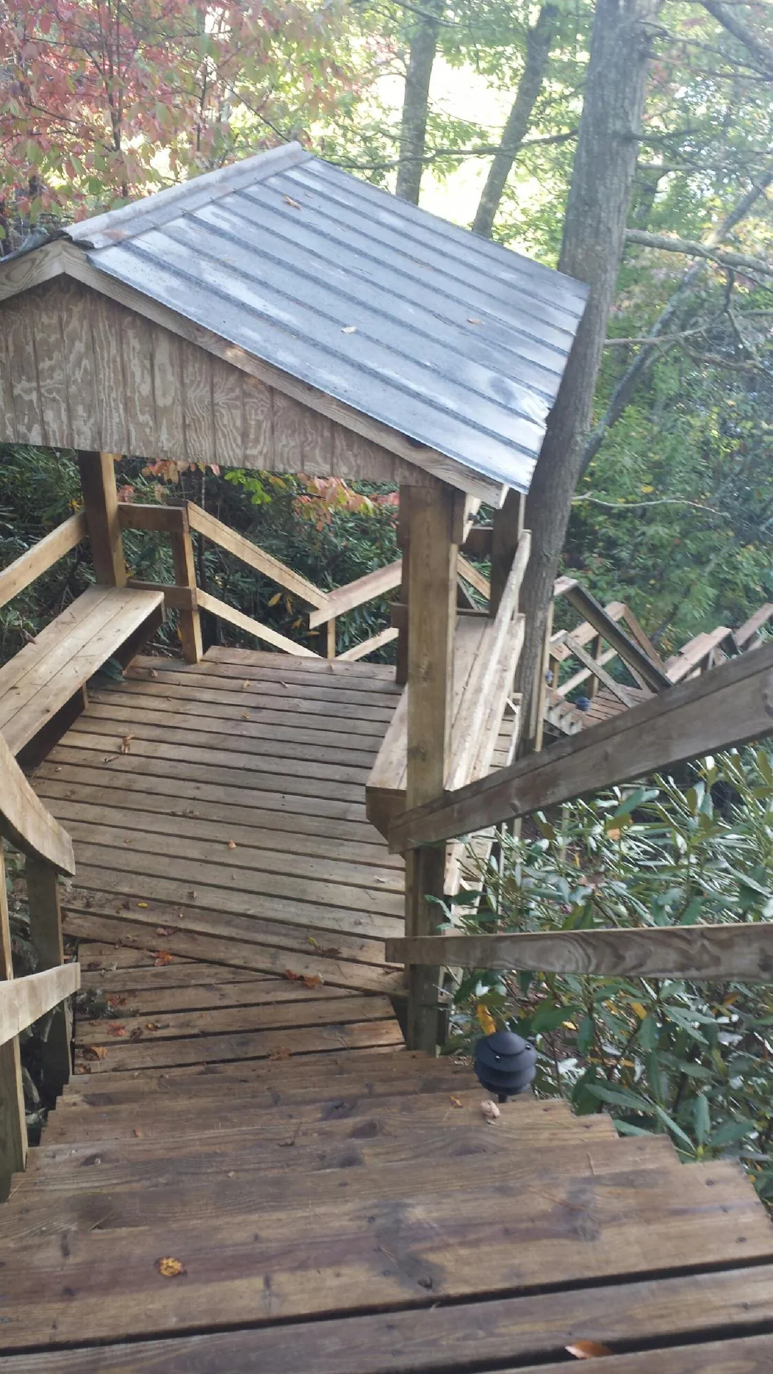 Metal roofed shelter over wooden steps on a wooded walkway — Skylight Repair & Installation work by our crew in Oakham